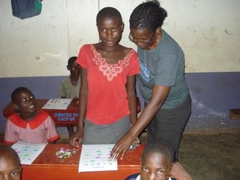 Ellen assisting one of her students with her coursework in Uganda