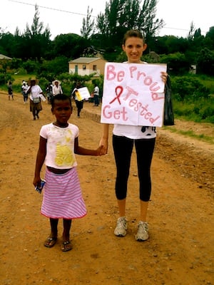 Woman with a child in South Africa holding a sign