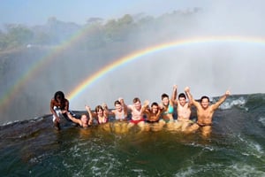 Volunteer with African Impact group with a rainbow