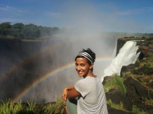 woman smiling at rainbow waterfall