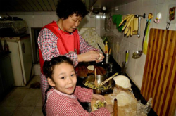 elderly woman and little girl cooking in kitchen