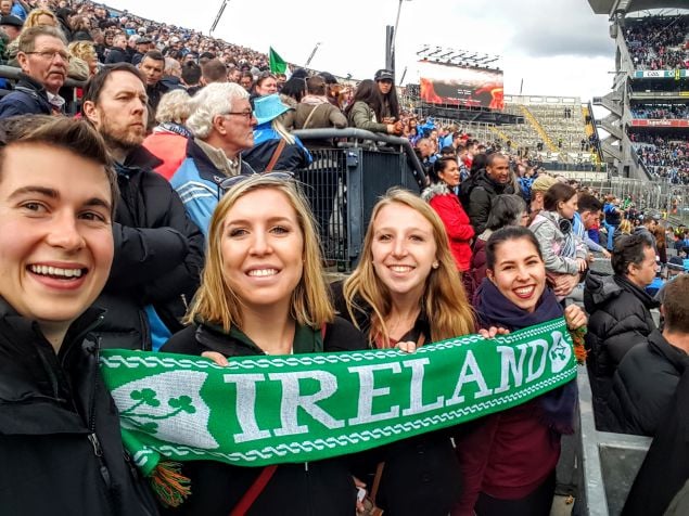 UCD students holding ireland scarf and smiling