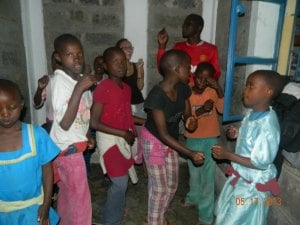 The kids trying to teach Paula dance step to the upbeat Kenyan music.