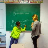 student and teacher at chalkboard
