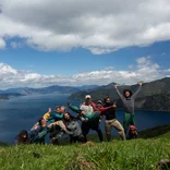 Students celebrate above the coastal waters of New Zealand.