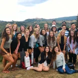 Students smiling on a field trip in the rolling Tuscan countryside.
