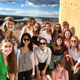 group of students on a balcony with the Arles skyline behind them on a sunny day