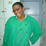 student wearing a green lab coat and green scrubs