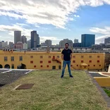 student standing on the rooftop of a building with the Cape Town skyline behind them