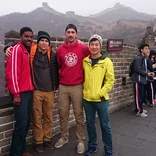 four students standing on the Great Wall of China on a foggy day