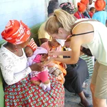 Volunteer attending to a sick baby
