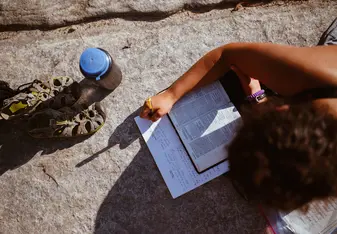 girl studying bible by Lake Superior
