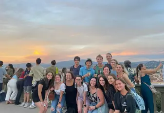 A group of CET Florence students posing in front of a sunset