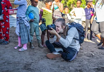 Impact Photography volunteer with community children