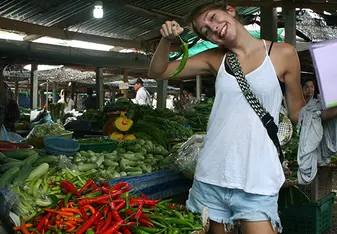 a teacher poses with a chili in a thailand market