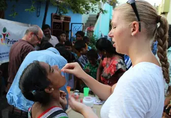 Volunteer gives a child vitamins