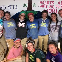 A photo of some of the girls in front of mural we painted at the school. 