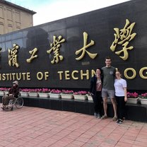 Two of my classmates and I standing in front of the University's sign!