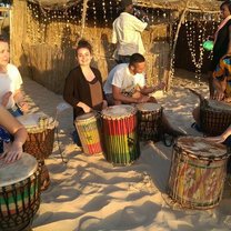 A group of volunteers learning how to play drums.