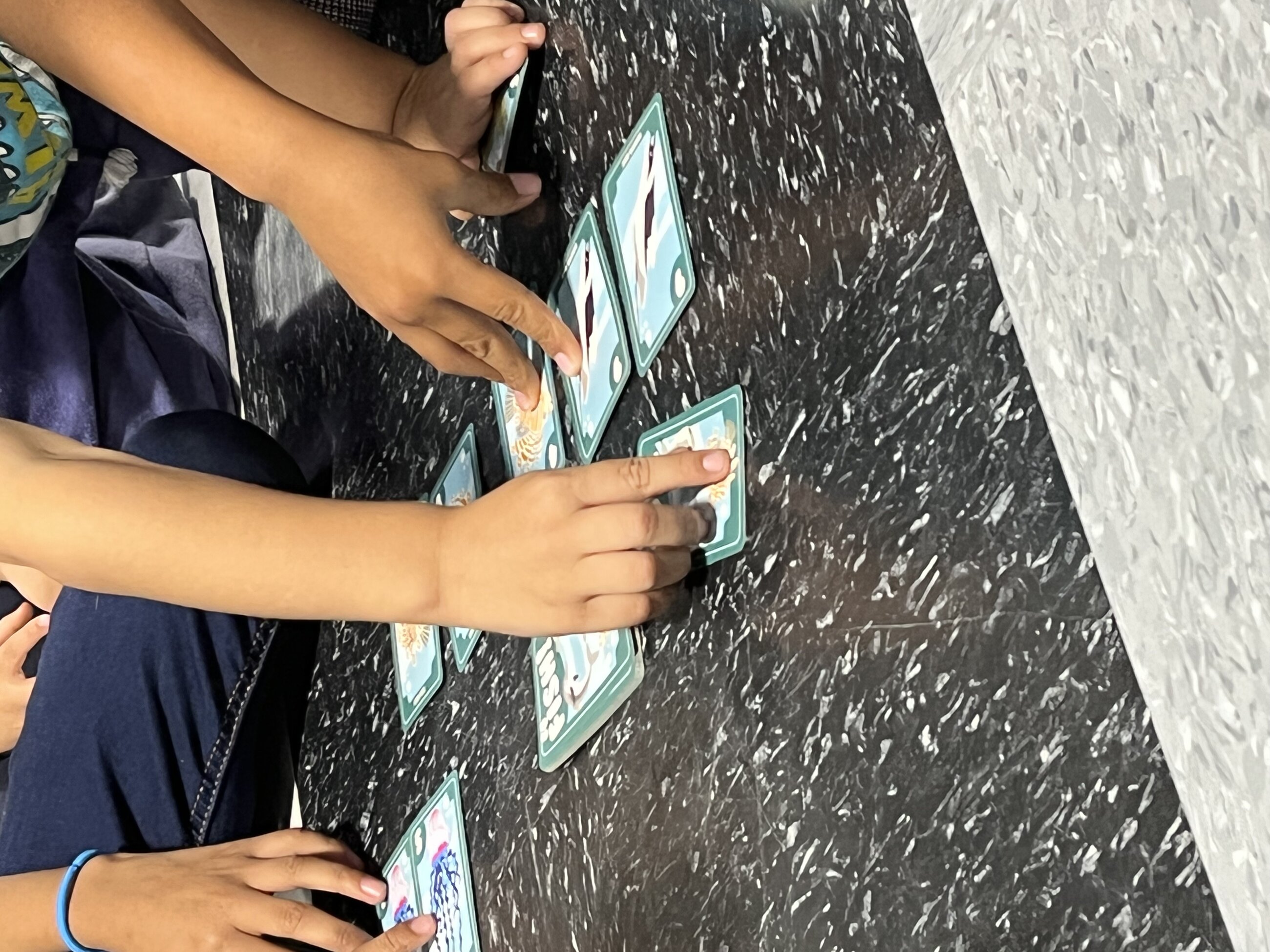 Playing cards with the kids at the respite center (faces hidden for privacy)