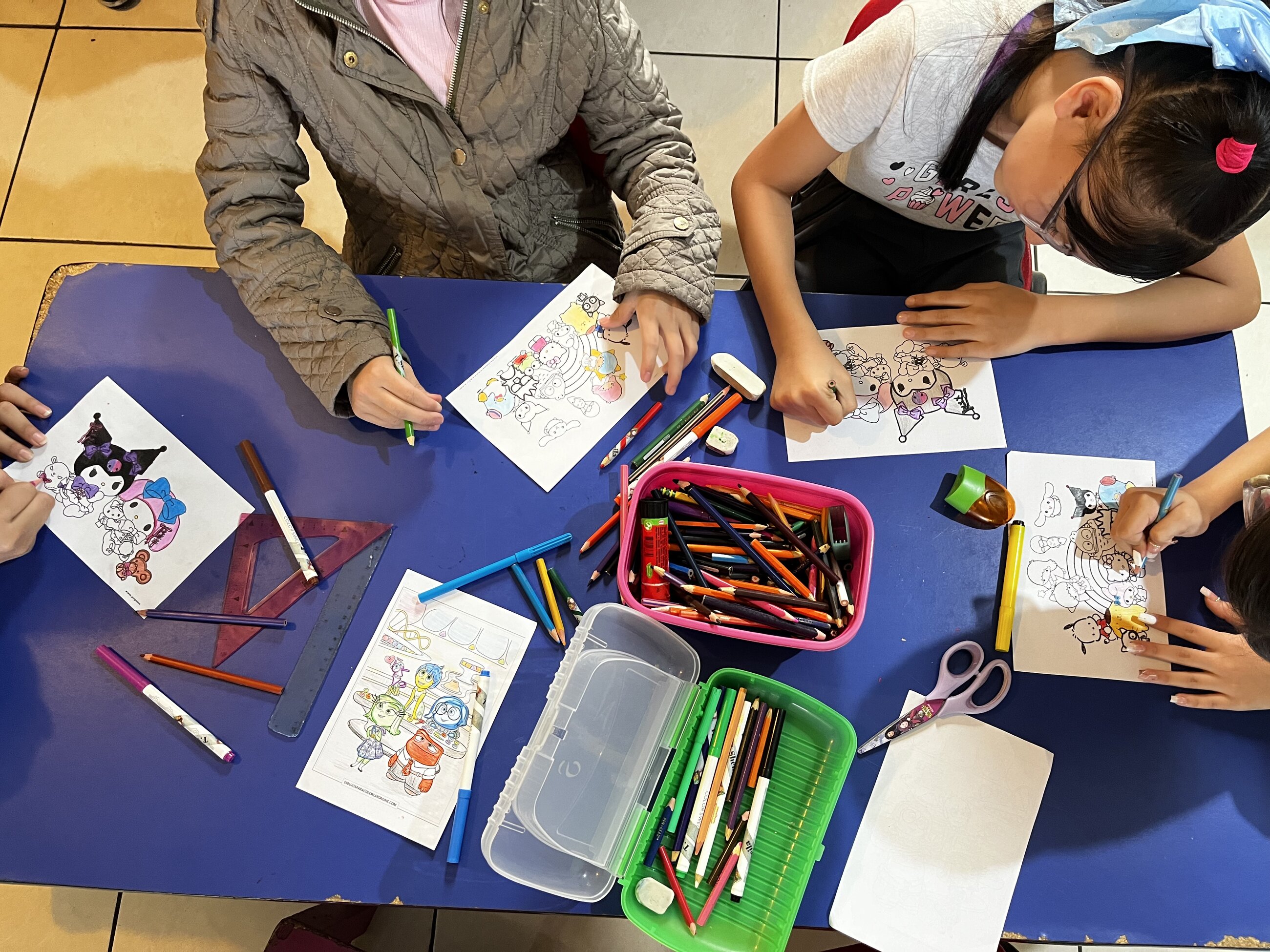 Kids drawing at a table with colorful pencils, during their class in divino niño