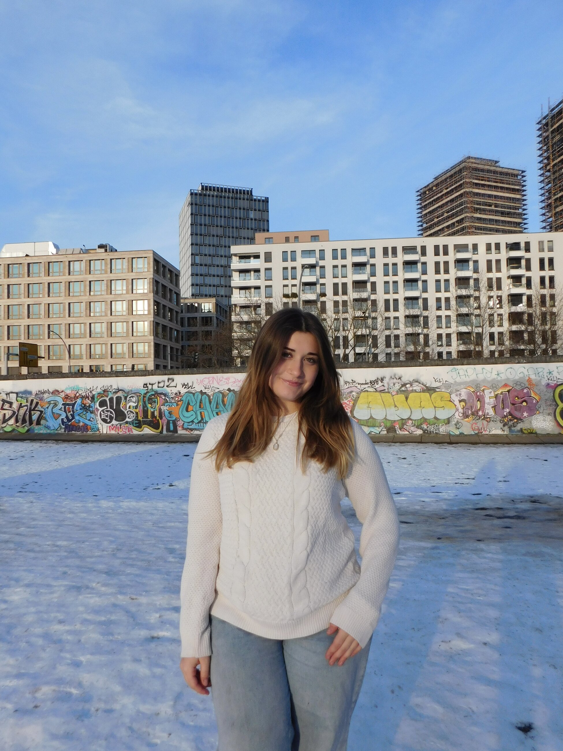 Ainsley Braun standing in front of the East Side Gallery in Berlin, Germany, February 2025 