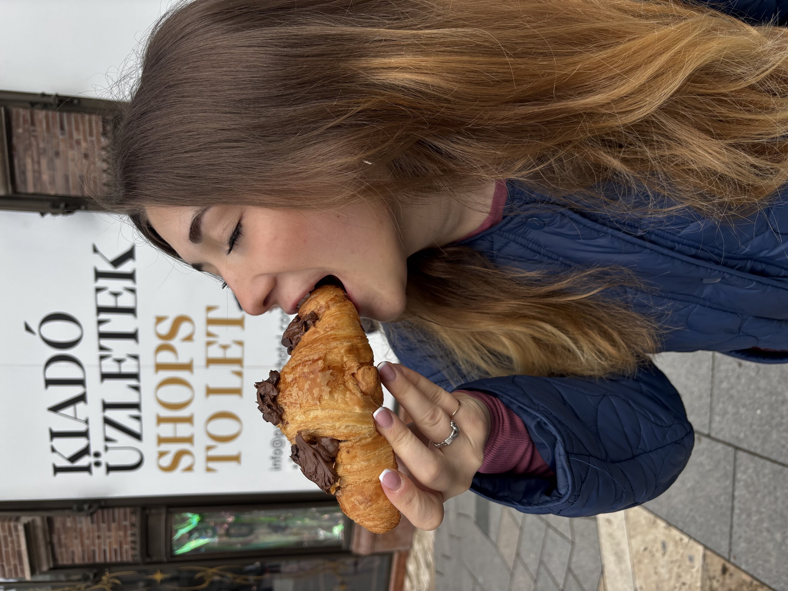 Ainsley Braun eating chocolate croissant in Budapest, Hungary, March 2025