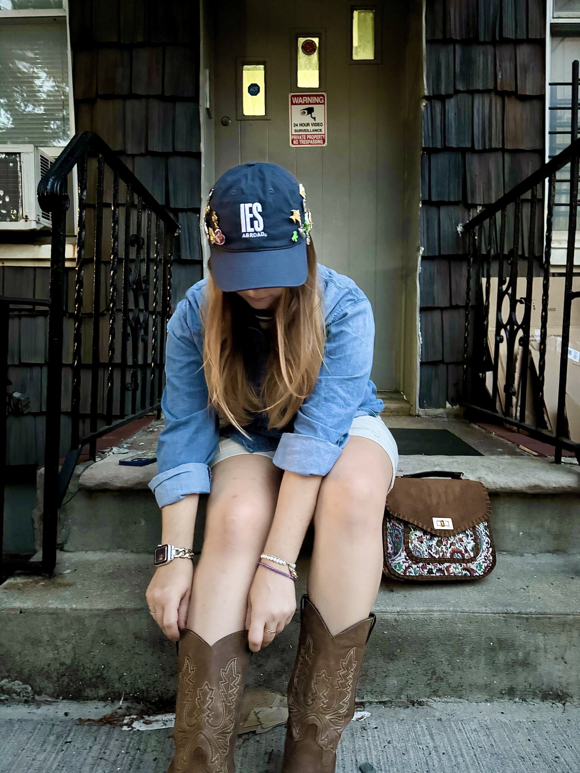 Ainsley Braun in an IES Abroad hat showcasing a pin collection, July 2025
