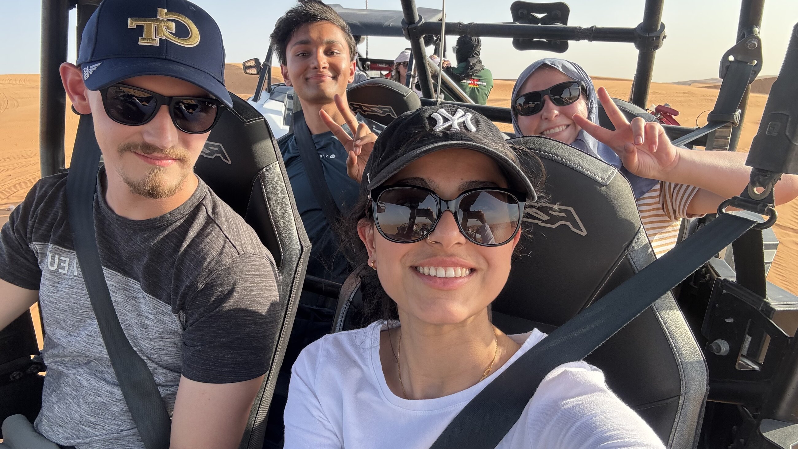 Exchange students riding a dune buggy through the desert in the UAE.