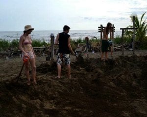 Kylie and fellow volunteers aerating and flattening the sand in the hatchery