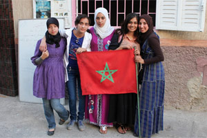 Volunteer with students in front of classroom