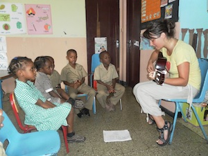 Woman playing guitar to children