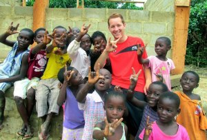 Students from a rural community outside of Ghana learn the Texas ‘hook em’; sign