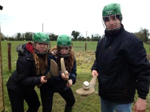 three students learning the sport of hurling