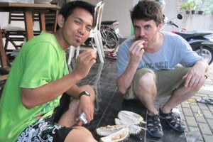 Joe trying durian with a local