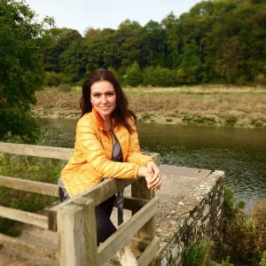 woman smiling by a bridge