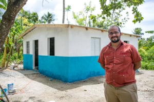 man in Cuba next to a house