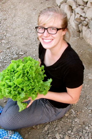 woman smiling and holding lettuce