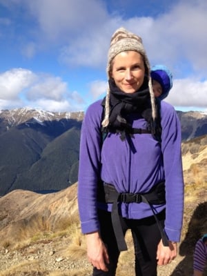 woman with a baby backpack hiking the mountains