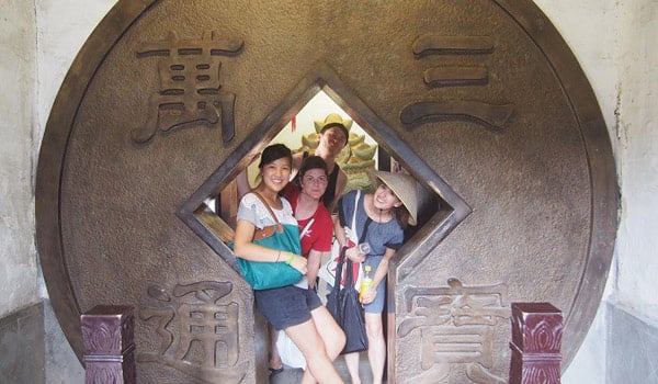 Shanghai interns inside an ancient Chinese coin in the Water Town, Zhouzhuang