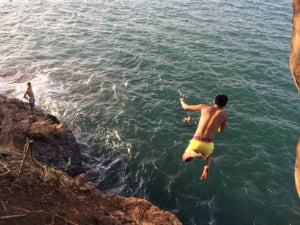student cliff jumping at Flamingo Beach 