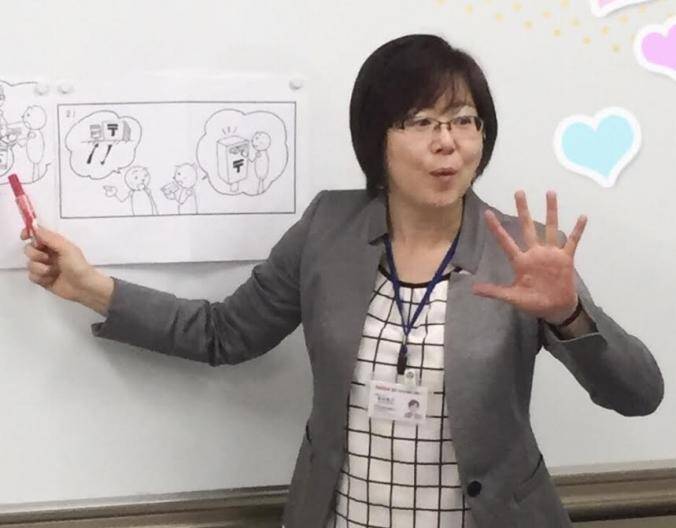 woman teaching in classroom pointing to a whiteboard