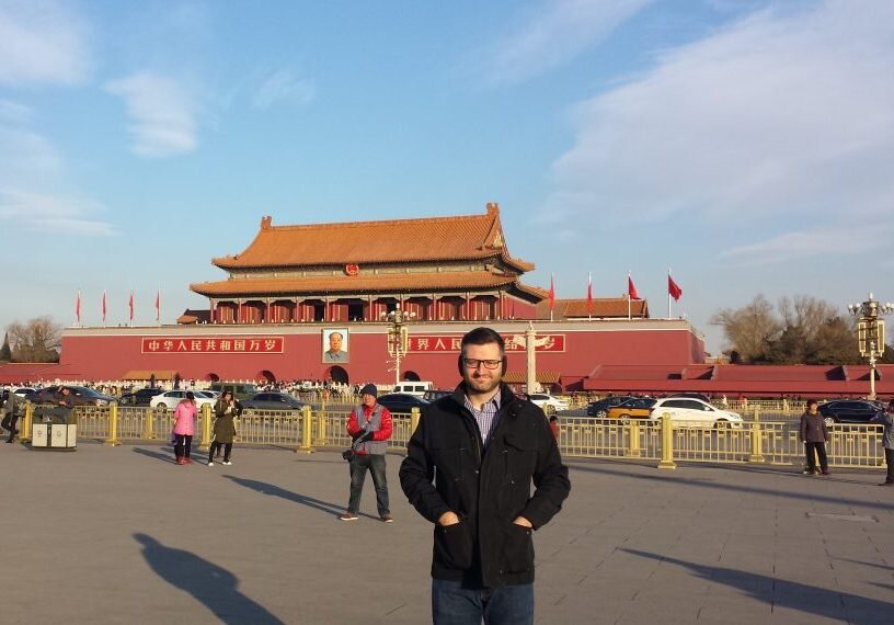 man standing in front of Chinese building