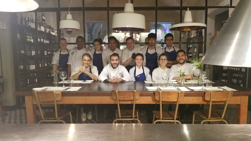 Global Experiences Internships in Florence, Italy Group of culinary interns wearing chef uniforms and posing around a table.