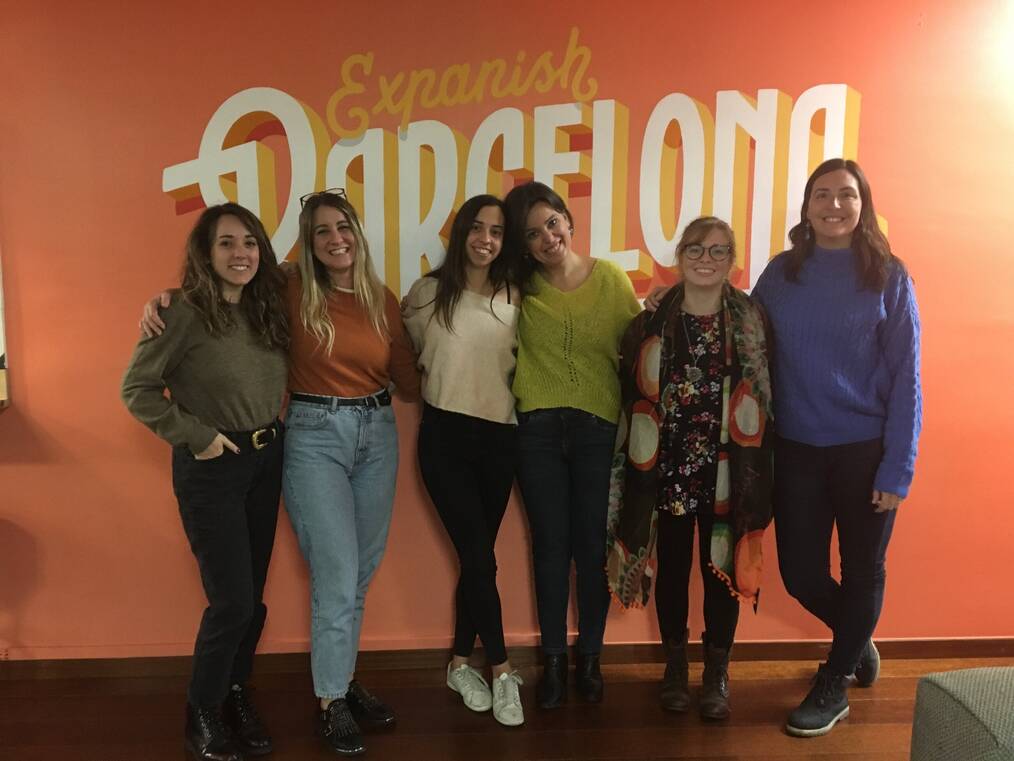 Six women standing together and smiling.