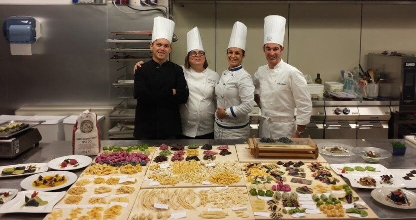 Manuelina Culinary Italy by Mary Four chefs in a kitchen.