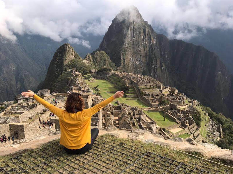 Woman sitting on top of Machu Picchu.