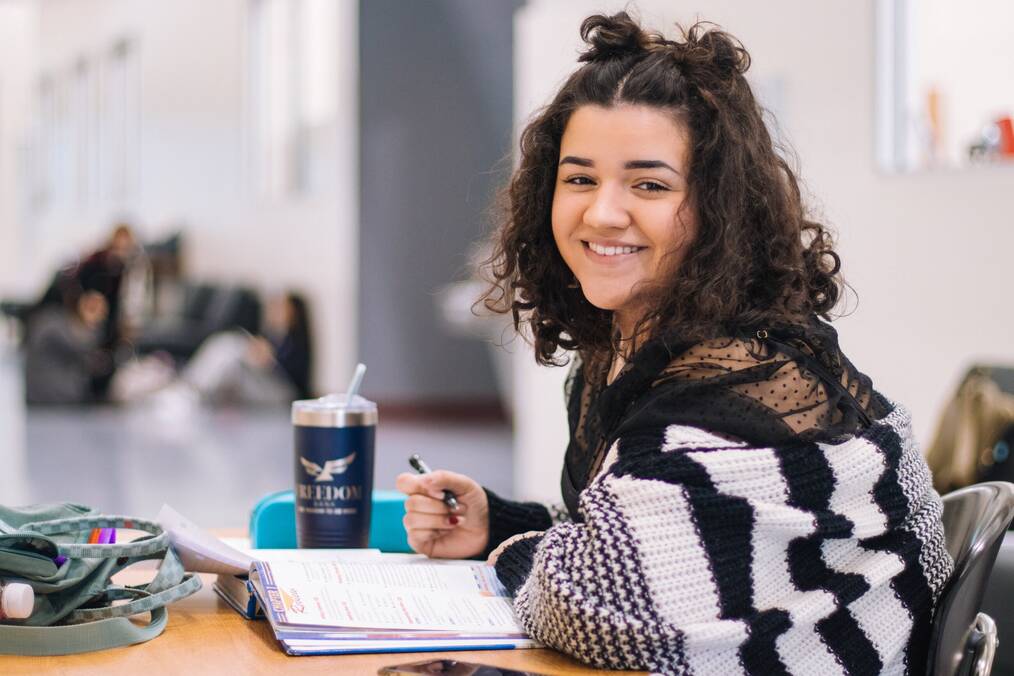 Student sitting and writing at desk