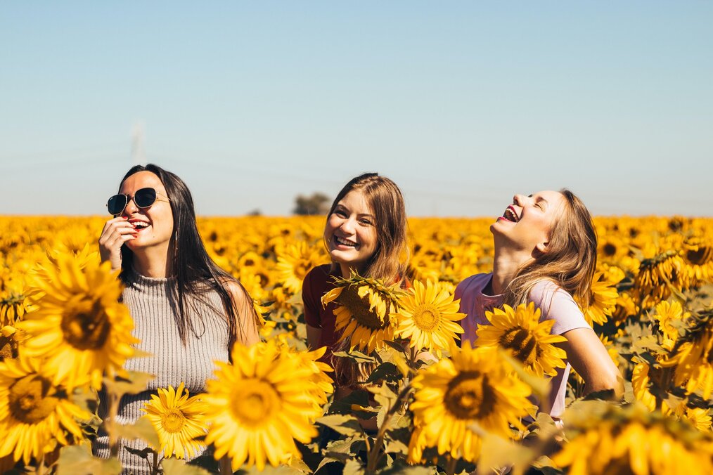 Photo by Antonino Visalli on Unsplash Three women in a field of sunflowers.