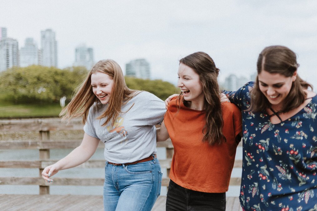 Photo by Priscilla Du Preez on Unsplash Three women smiling and laughing together.